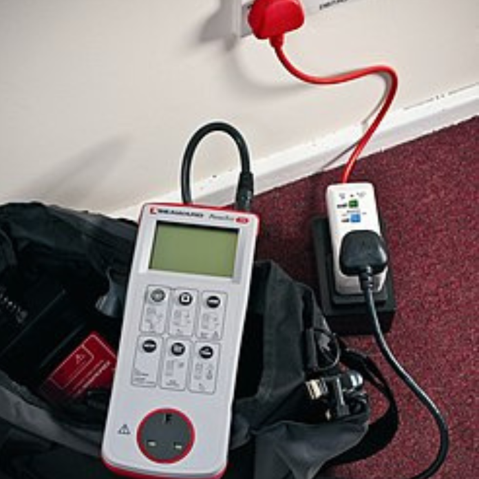 Portable appliance tester connected beside a wall socket