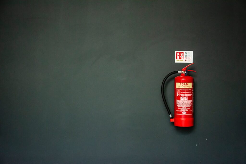 Red fire extinguisher mounted ready for inspection and servicing